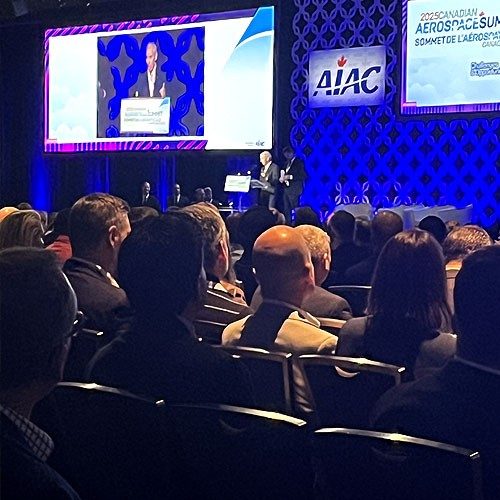 Attendees of the 2025 AIAC Conference sitting in the audience, watching a presentation